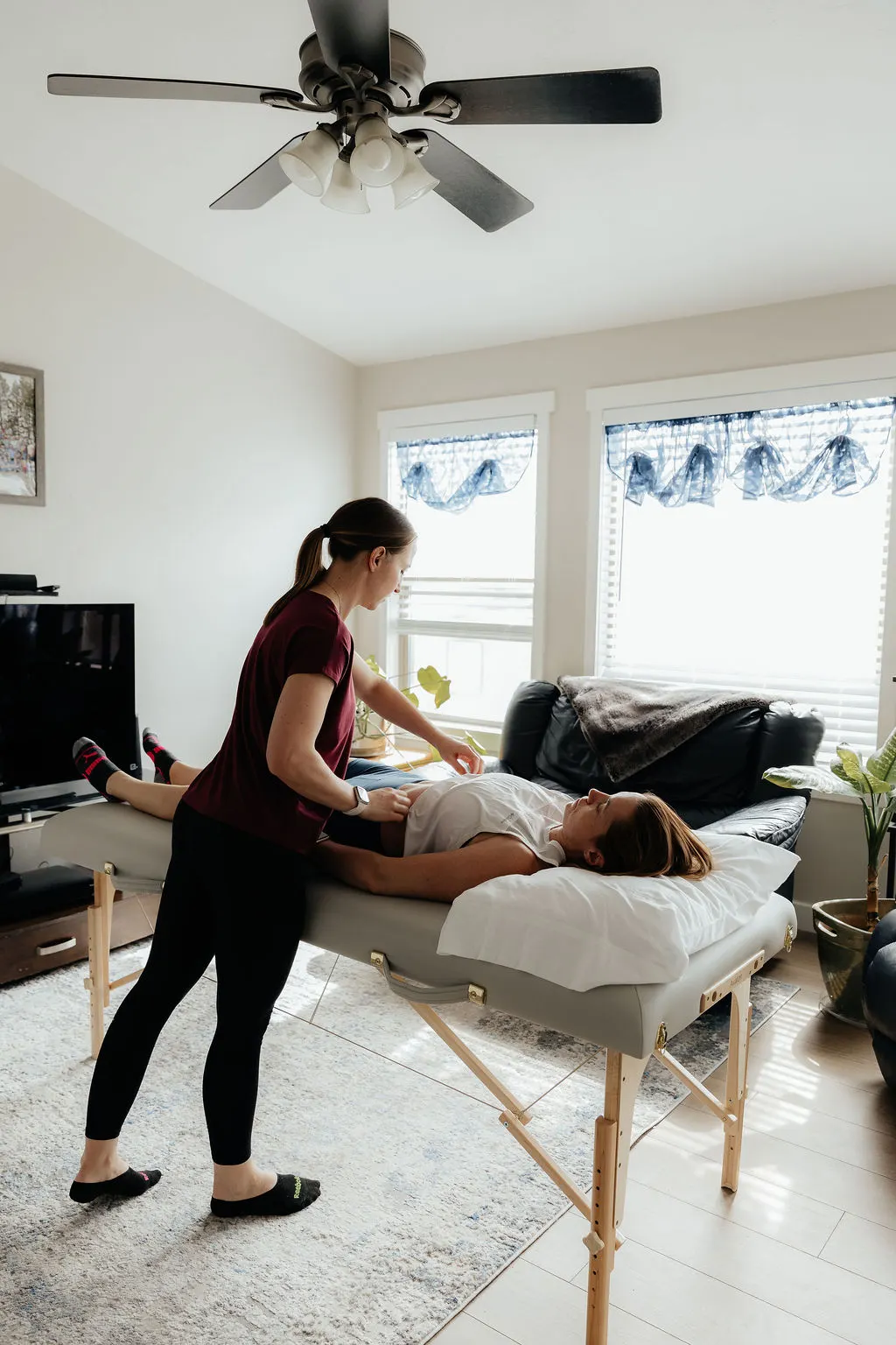 Dr. Danaya Kauwe performing a comprehensive pelvic and hip assessment during a 60-minute in-home treatment session